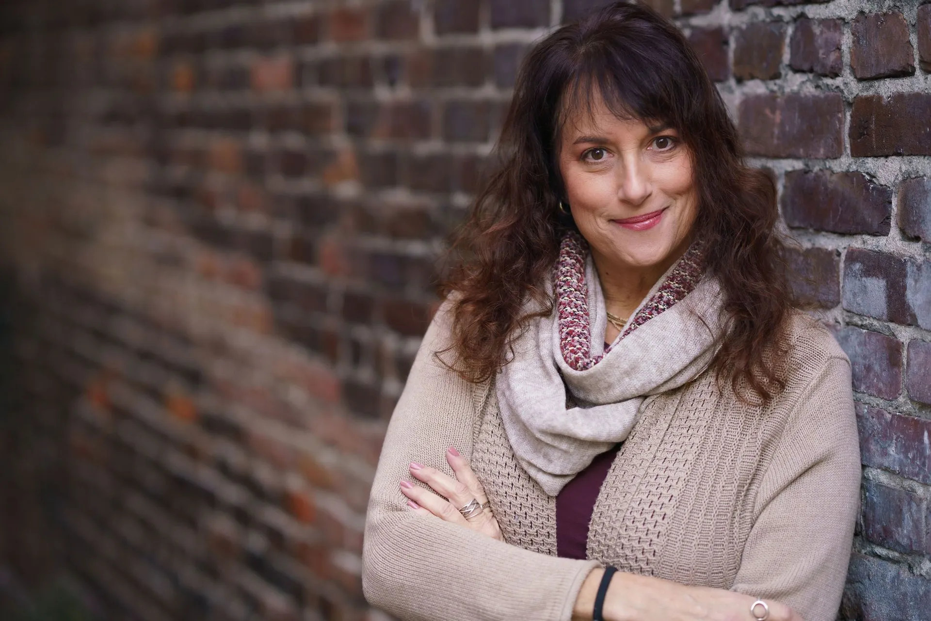 Issy Kleiman, MA, LMFT, AAMFT Approved Supervisor, smiling warmly against a brick wall
